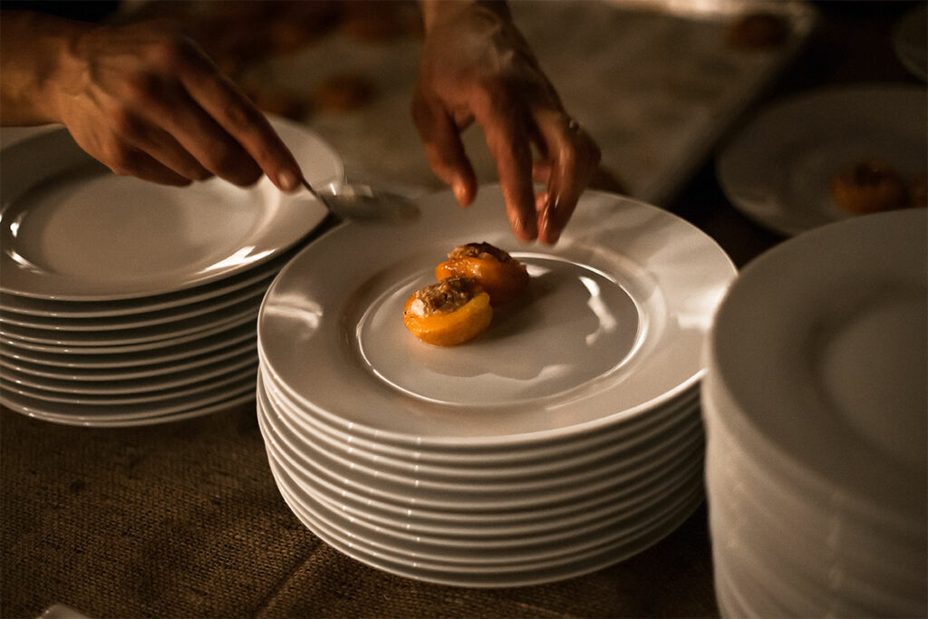Stuffed apricots being served on dish.