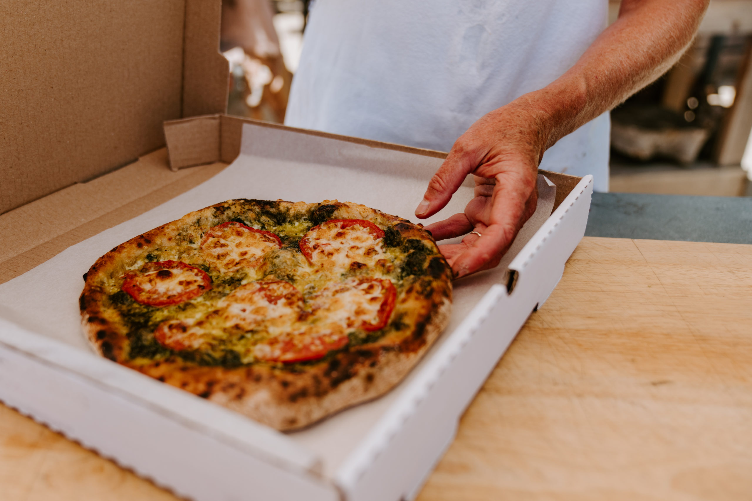 Pizza being placed in to-go box.