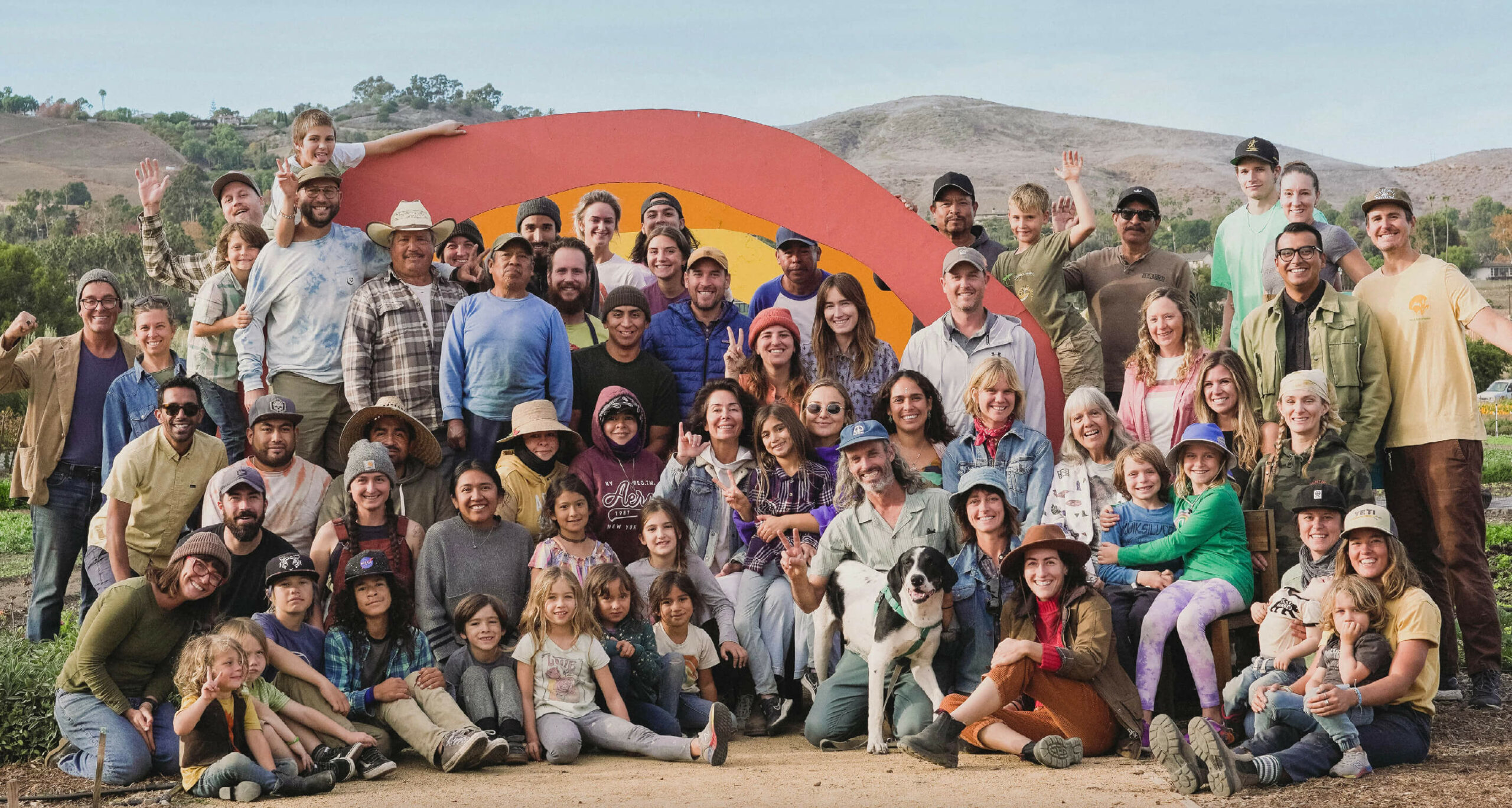 The Ecology Center staff pose in front of the rainbow on the farm.