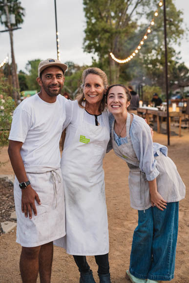 three volunteers at a dinner event on the farm