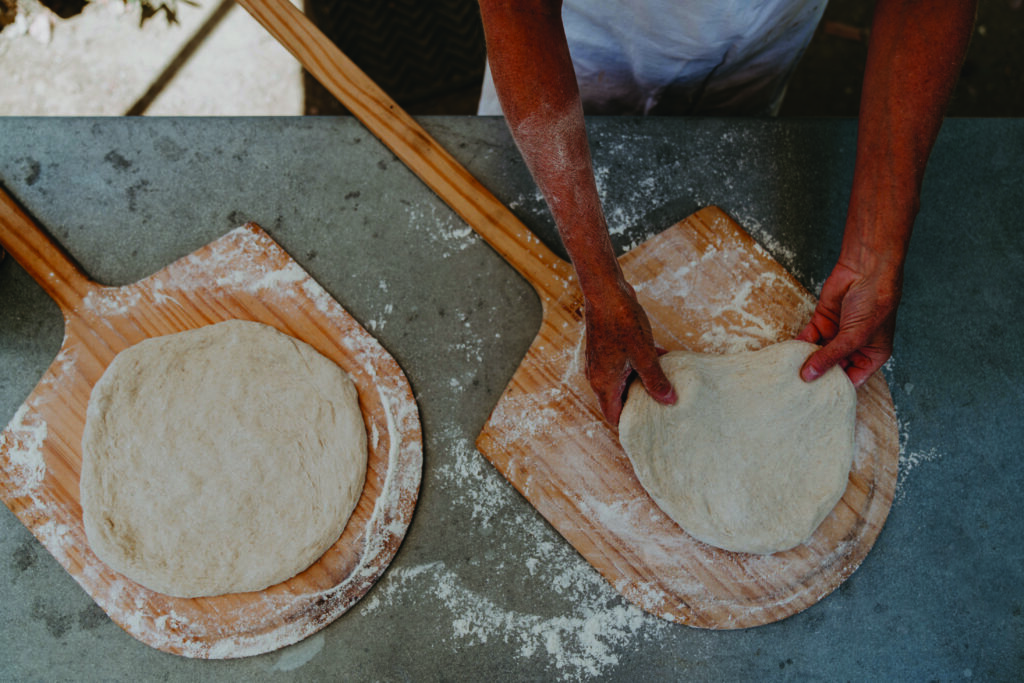 pizza dough being stretched onto a paddle