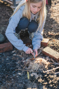 girl striking flint to start a fire