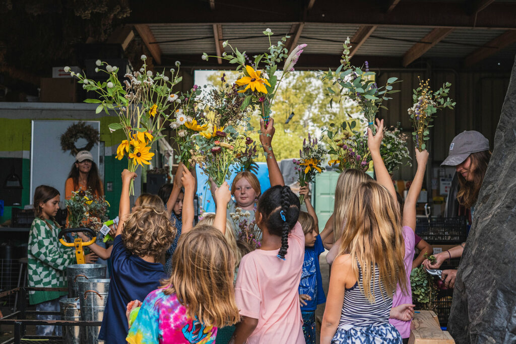 children holding bouquets of flowers over their heads