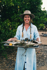 Chef Sarah Glover holding a tray of fish at Community Table