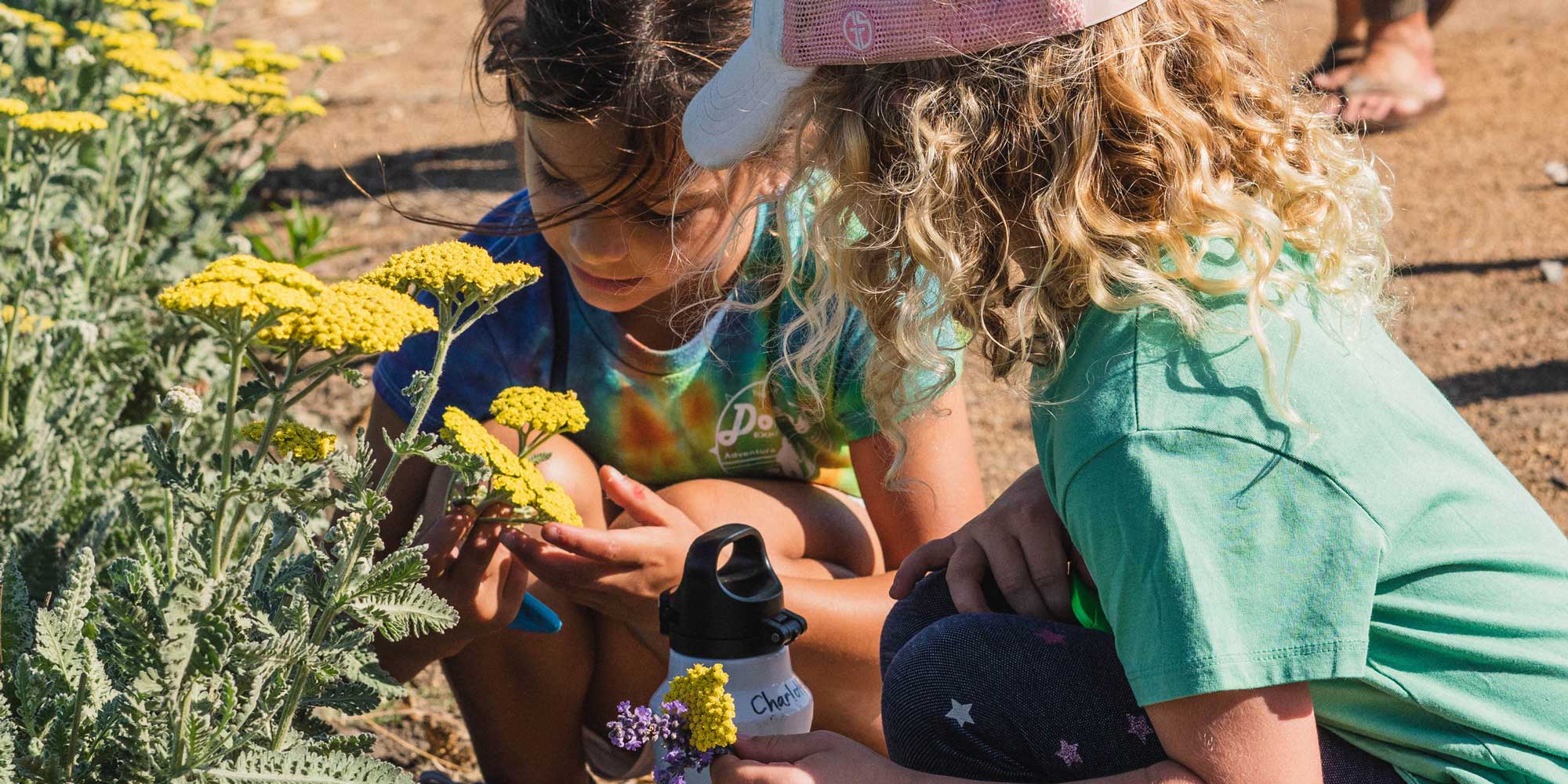 Two children examine flowers.