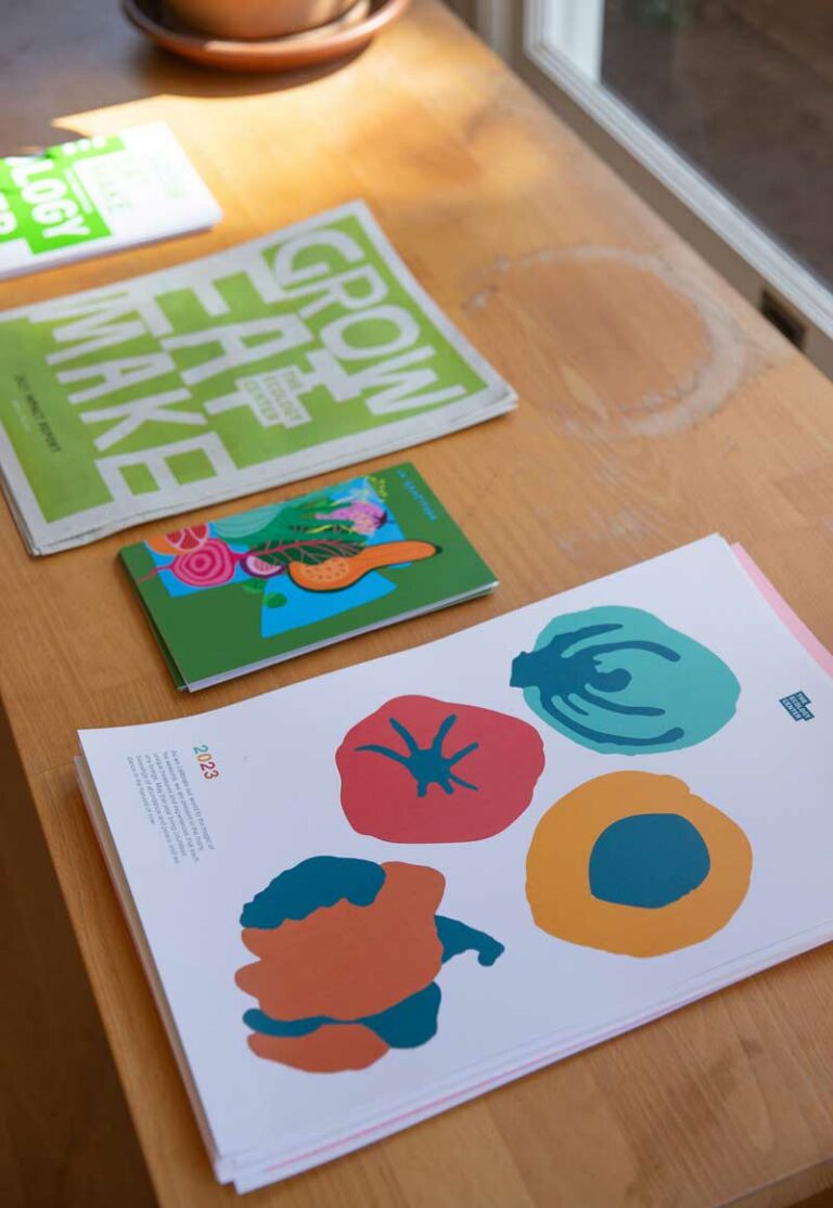 Posters laid on a wooden table featuring colorful fruit designs.